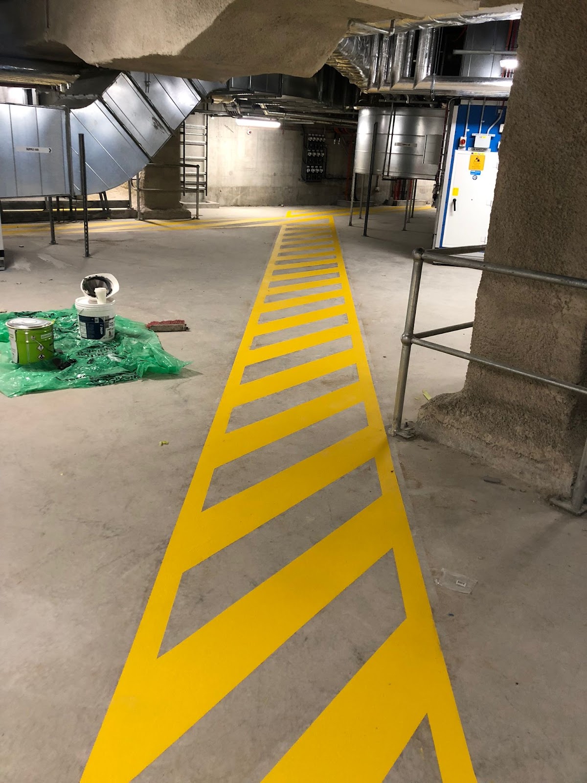 Yellow hatched safety line marking in an underground plant room