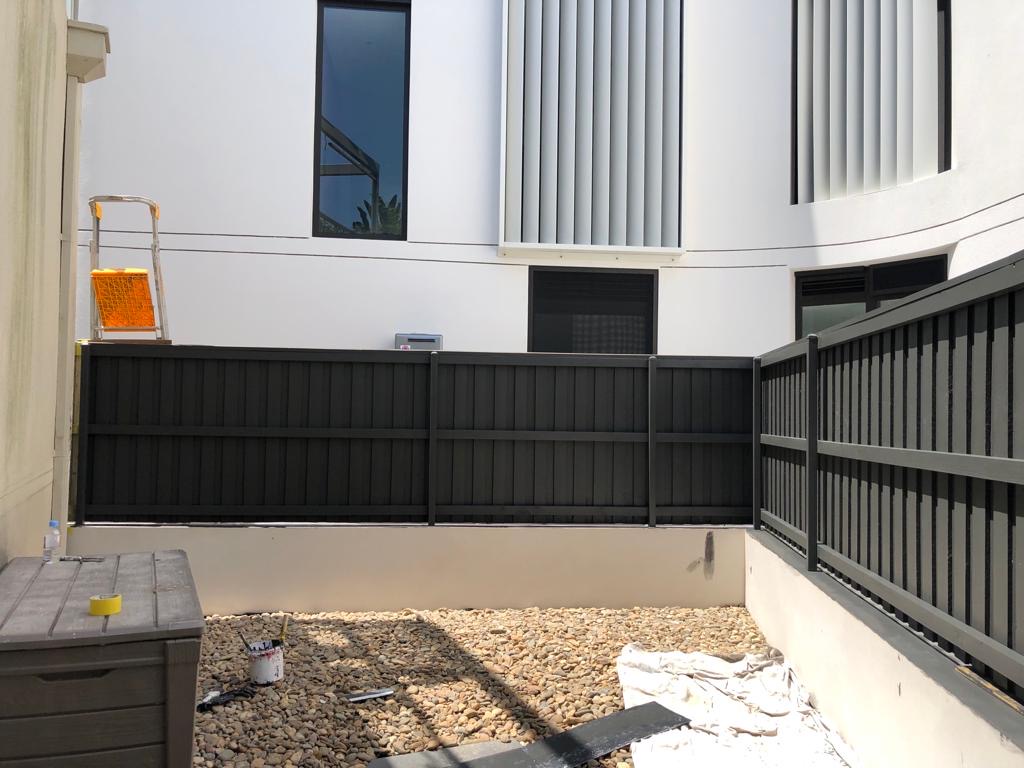 Black painted slat balustrade against white render